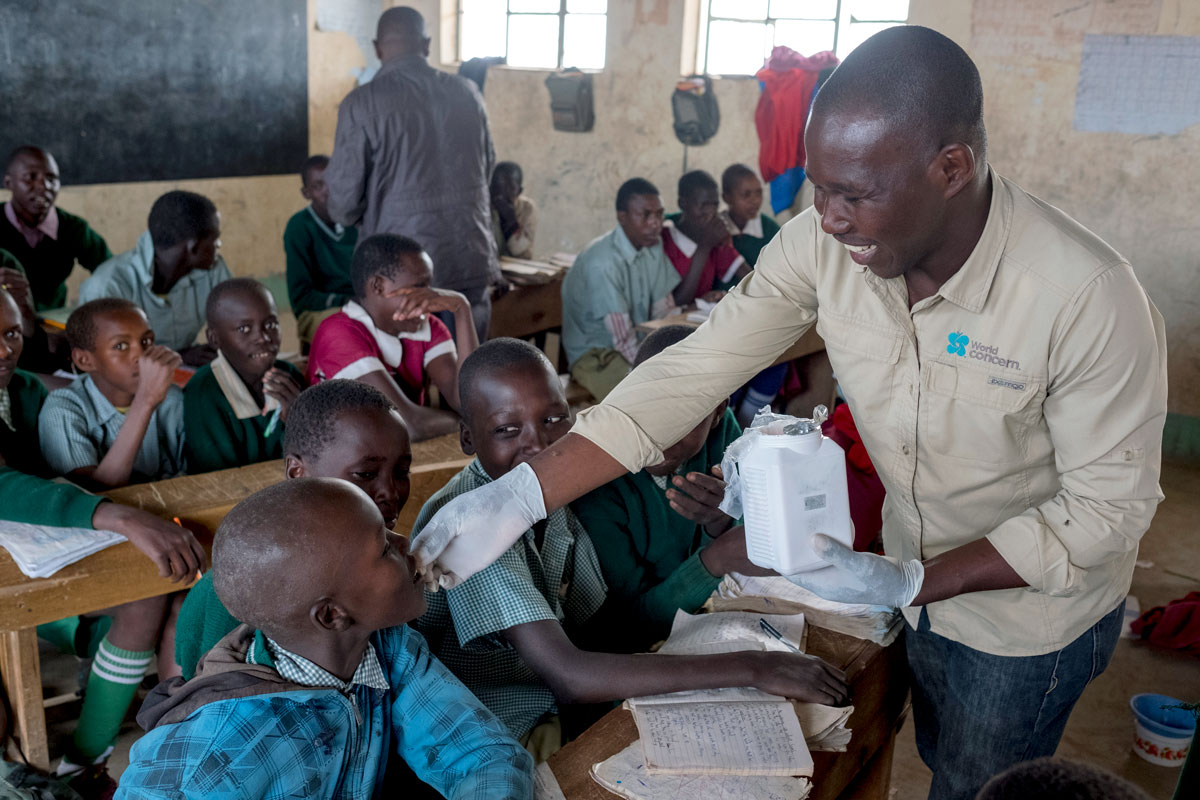 Harrison Macharia distributes deworming medication.