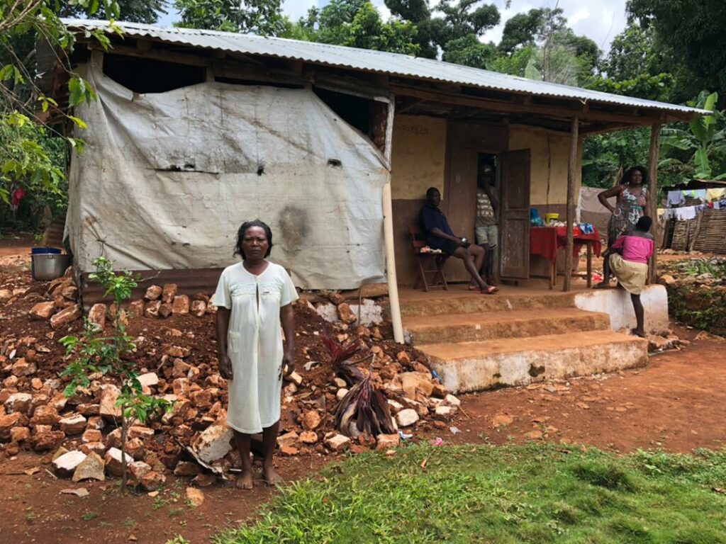 Astrelle stands outside her home, where collapsed walls have been replaced 