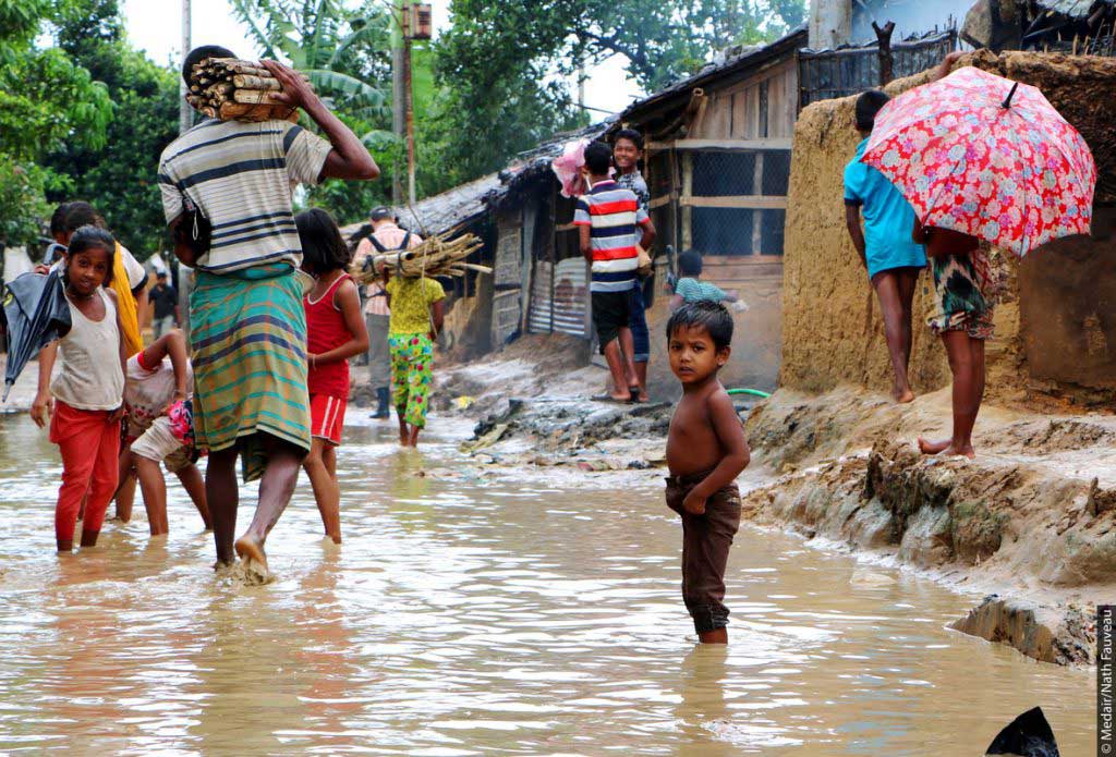A boy wades through water in a refugee camp in Bangladesh
