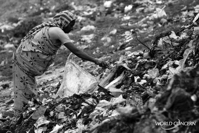A woman picks through rotting trash in a slum in Dhaka, Bangladesh.