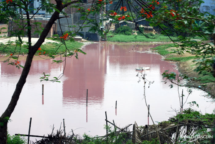 Near a Bangladesh slum, heavy pollution near a turned this lake red. 