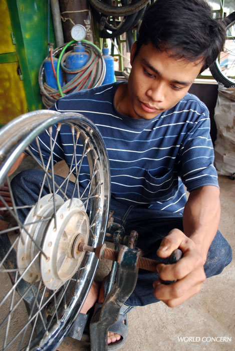 Young men learn how to repair motorbikes in Poi Pet, Cambodia, a border community at risk for Child Trafficking.