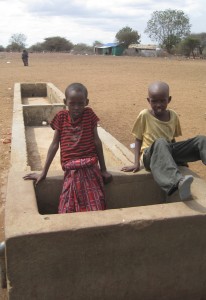Kids play in a dry water trough.
