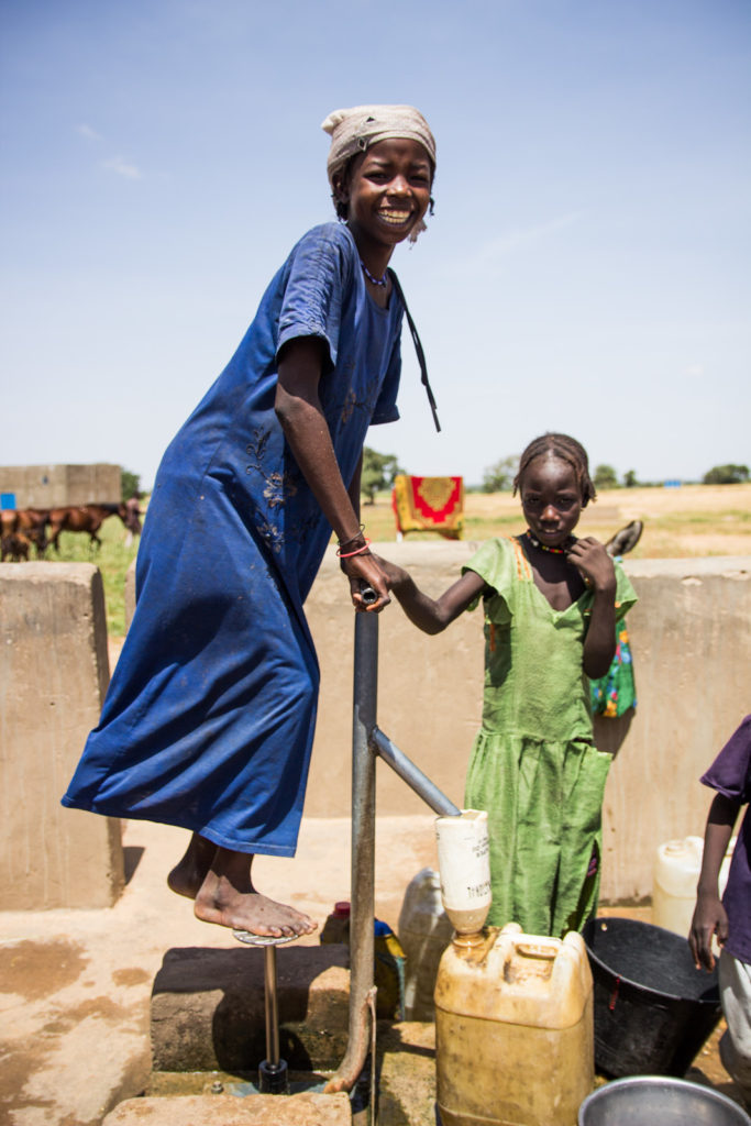 A girl draws water from a pump well.