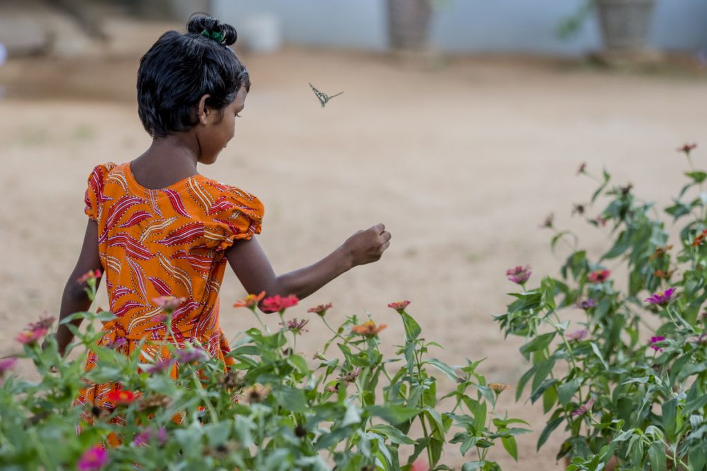 A young girl plays in a garden outside a children's home in Sri Lanka.