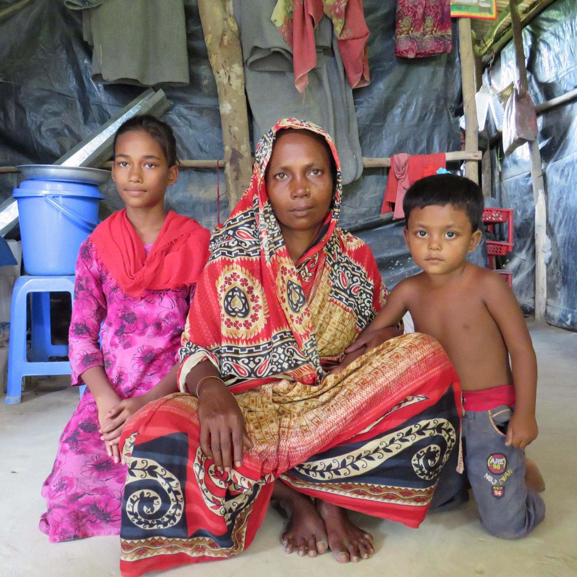 Khotija and her children sit inside their home.