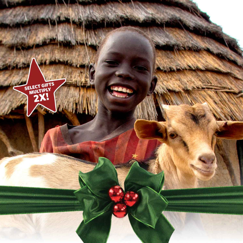 A boy holds a goat he received from the Global Gift Guide.