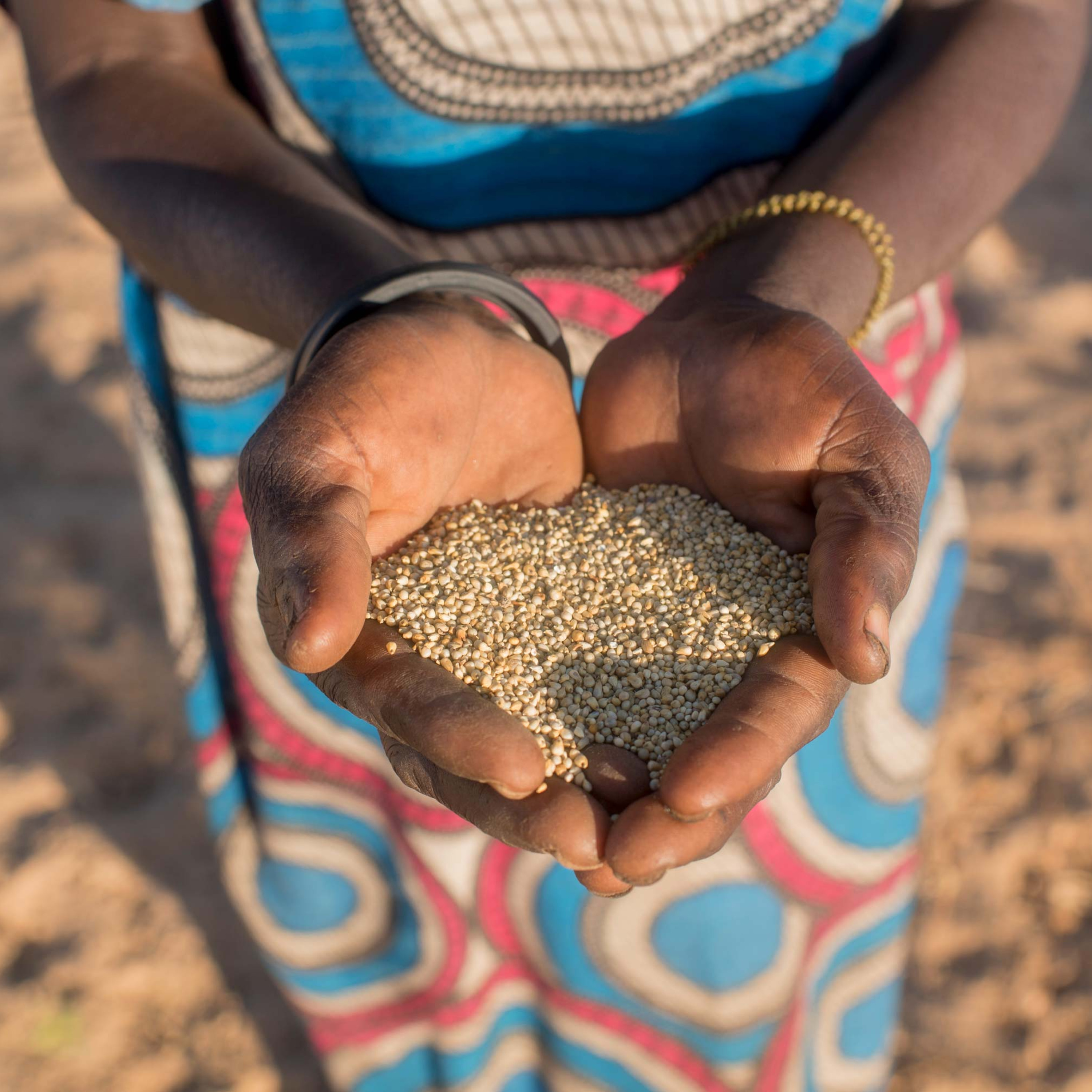 A woman holds grains.