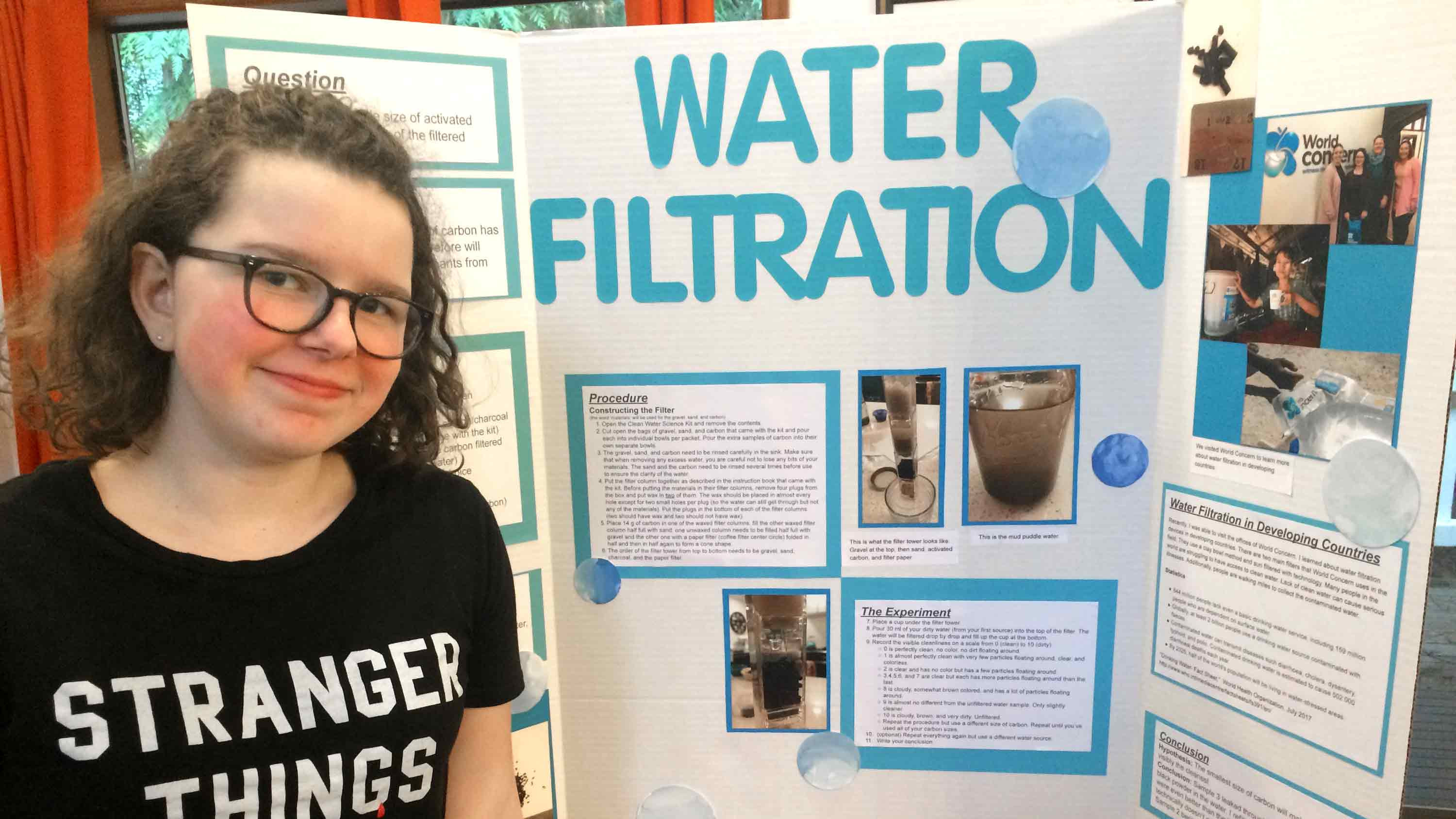 Fiona and her completed science fair project about water filtration.