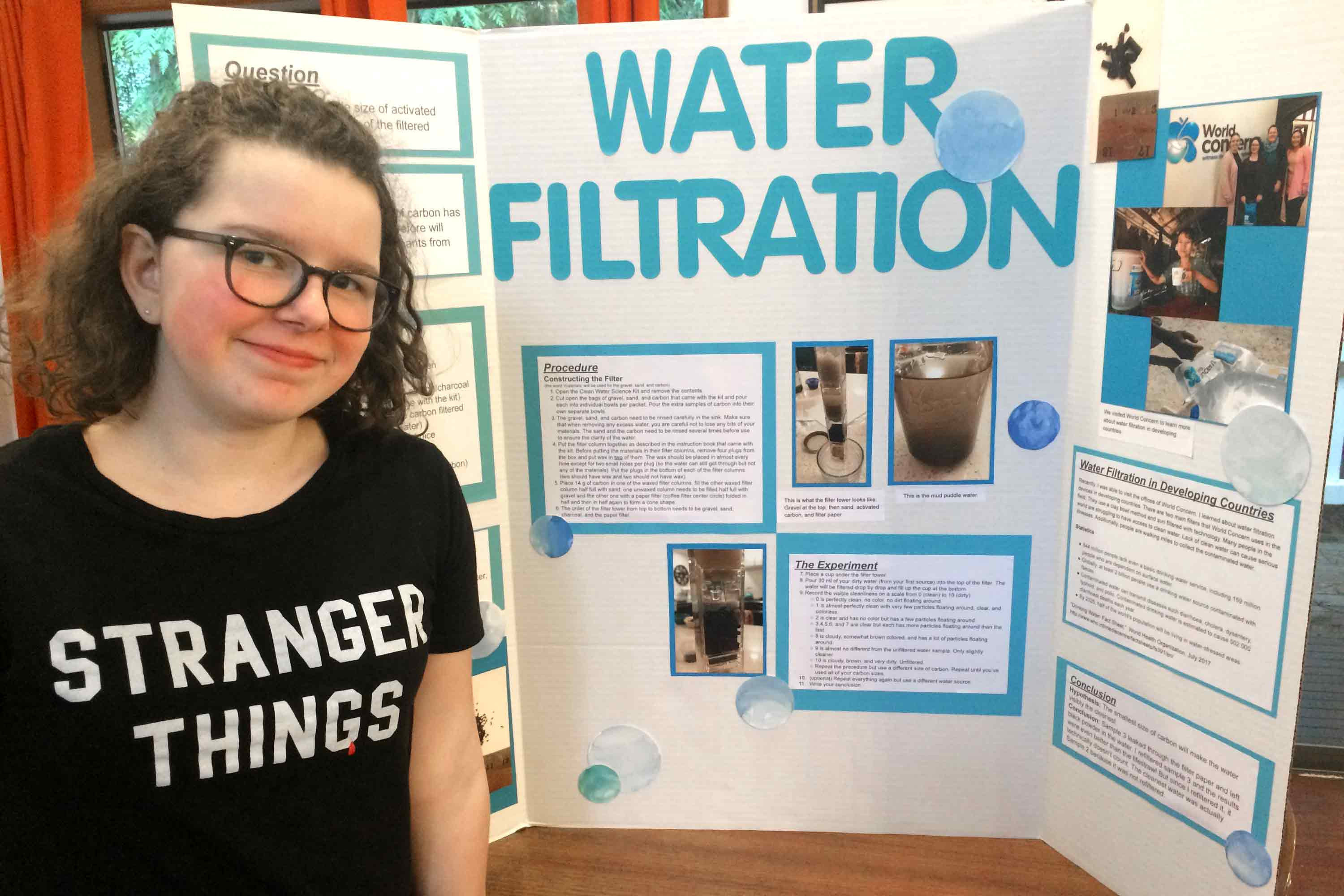Fiona and her completed science fair project about water filtration.