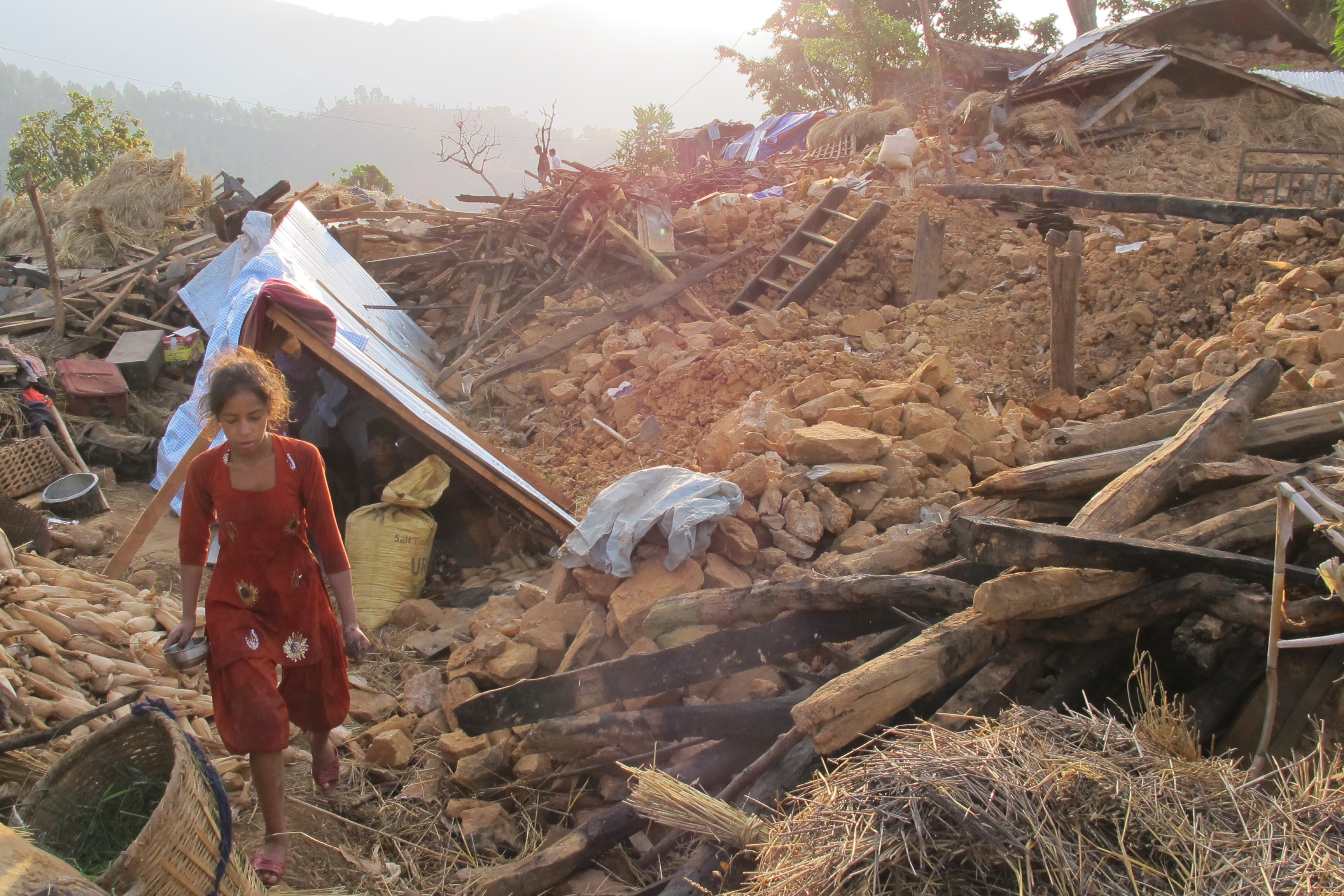 A young girl walks near her tent amidst the rubble in Khalte, Nepal.